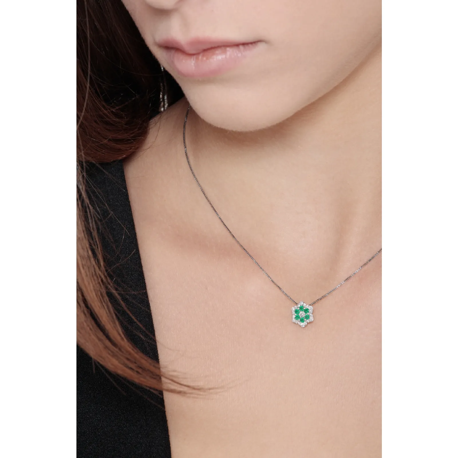 Collana in oro bianco 18k con pendente in diamanti e smeraldi.